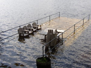 High water on Berry Bay swamps a dock in April 2007. In addition to major damaging floods, such as those in 1953, 1998 and 2005, nuisance floods that linger for days are common on Ossipee Lake, creating hazards by sending personal property and debris out into the lake. Alliance Photo 