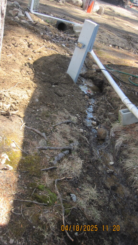 An electric pedestal and extension cord are seen in a drainage ditch at Ossipee Lake's Wabanaki Campground. Photo: N.H. Department of Environmental Services